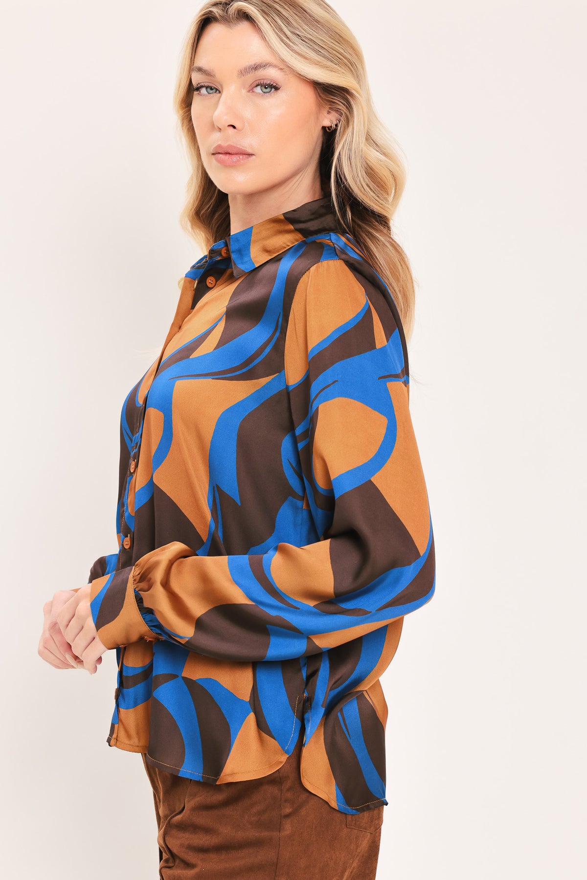 A woman modeling a long-sleeve button-up shirt with an abstract wavy pattern in brown, blue, and black | Flying Tomato