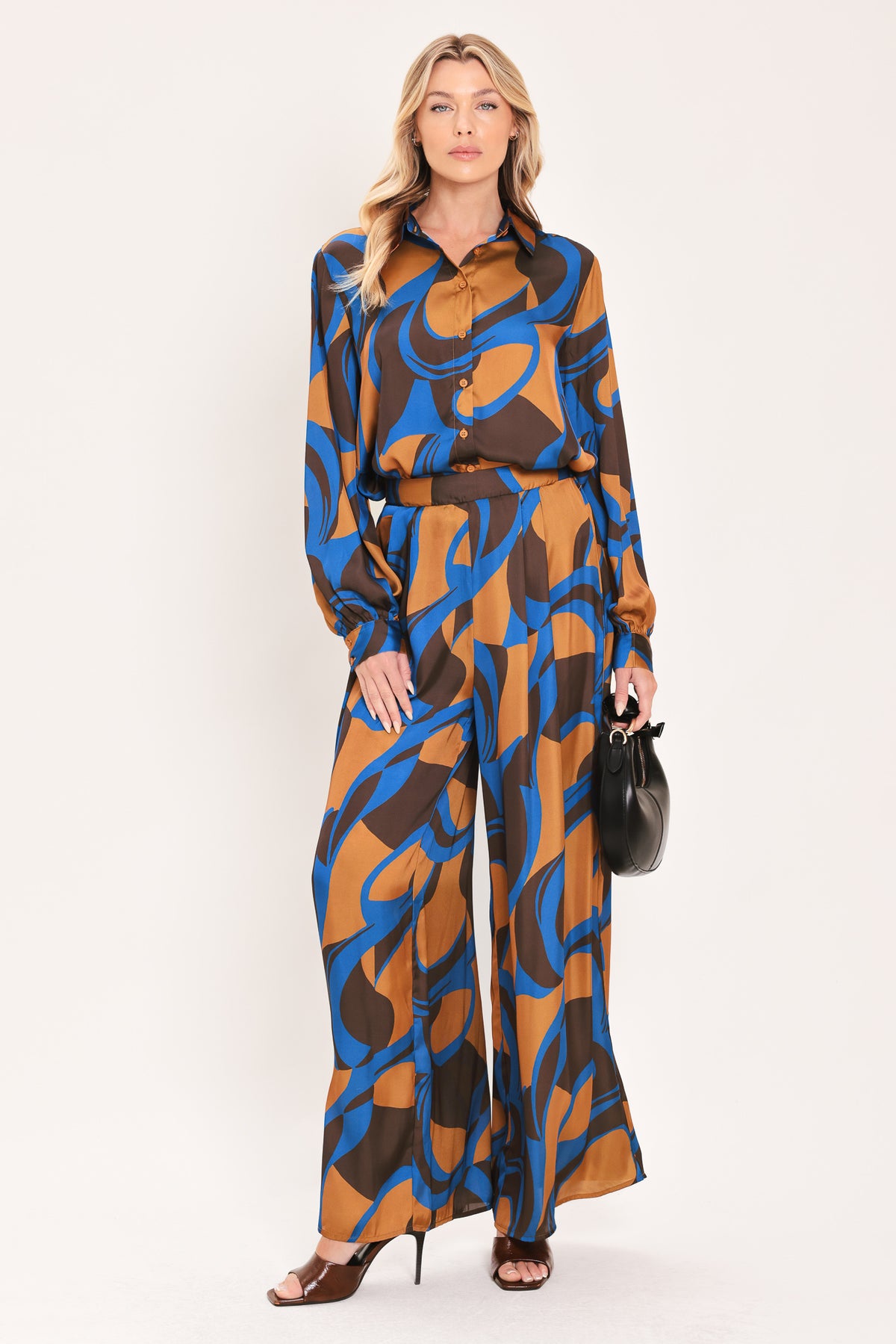 A woman modeling a long-sleeve button-up shirt with an abstract wavy pattern in brown, blue, and black | Flying Tomato