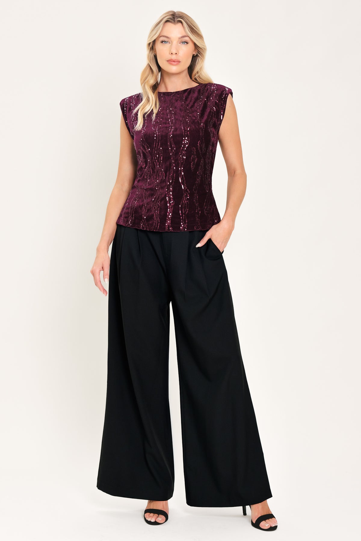 A woman modeling a sleeveless deep burgundy sequined top paired | Flying Tomato
