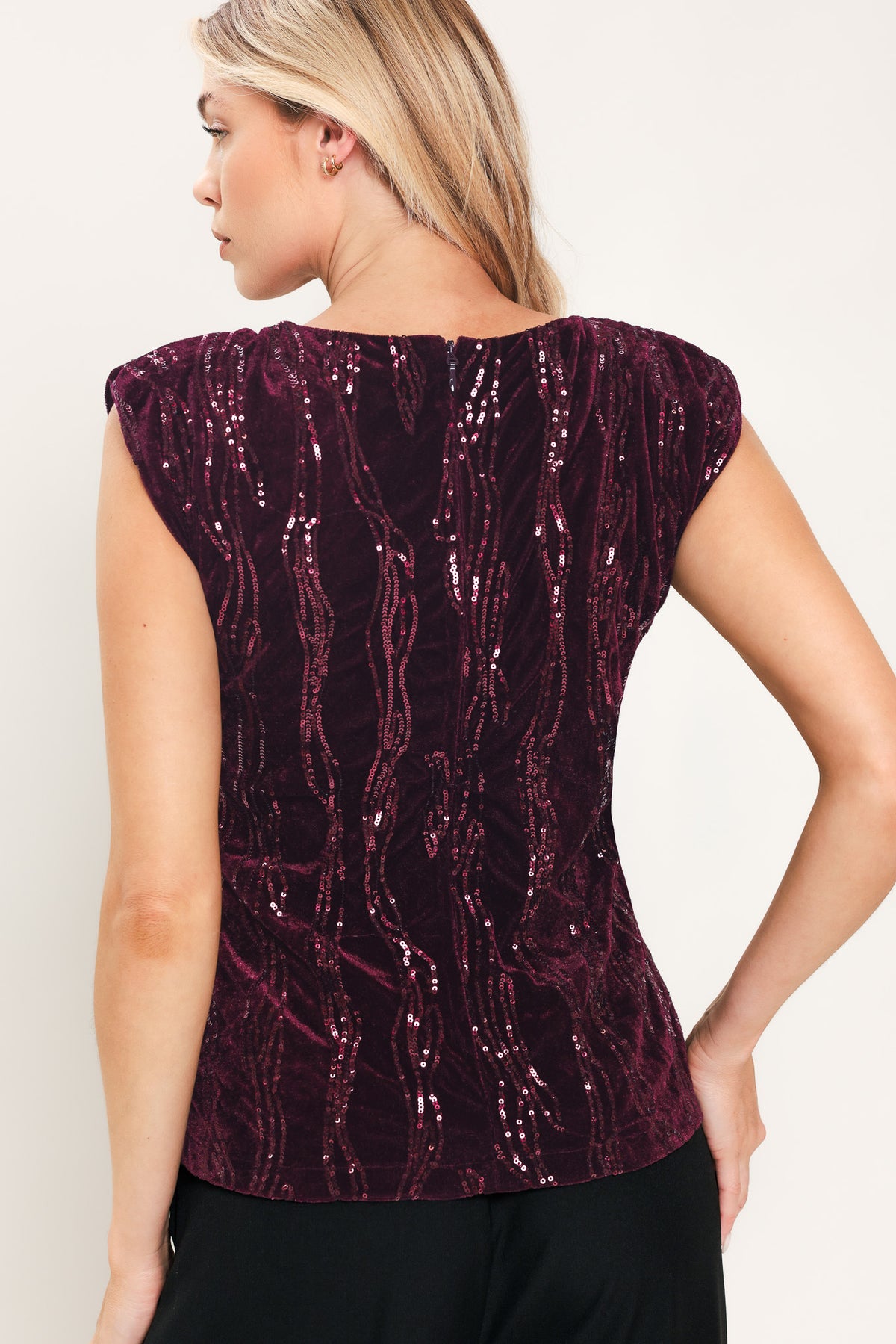 A woman modeling a sleeveless deep burgundy sequined top paired | Flying Tomato
