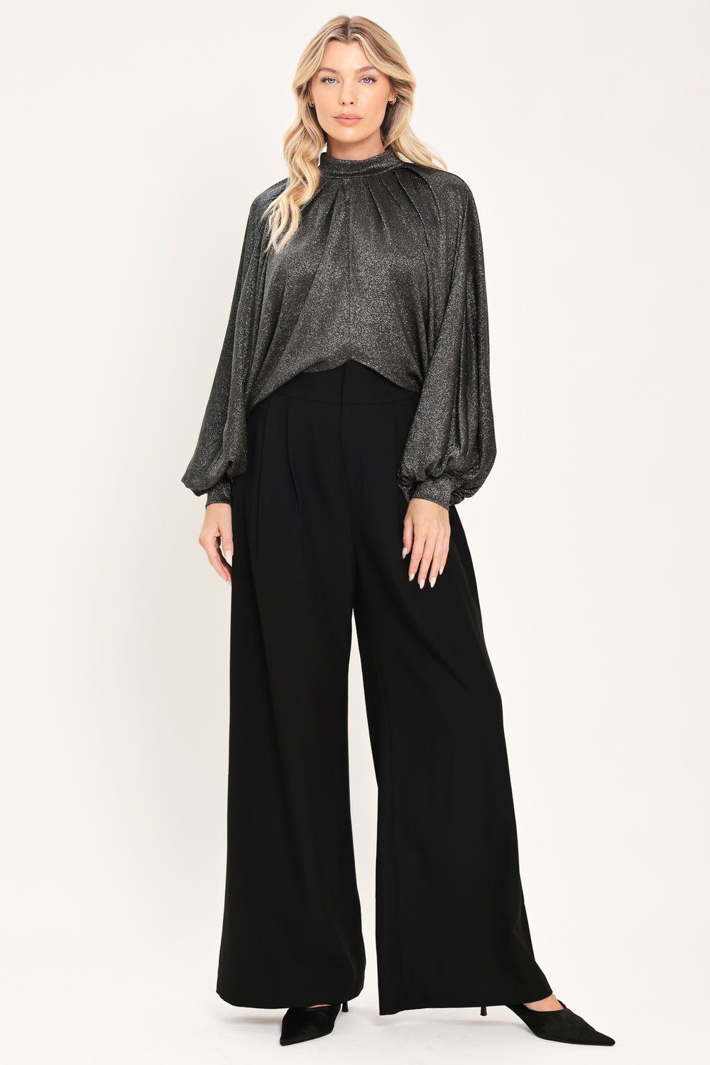 A woman modeling a dark gray metallic high-neck blouse with voluminous balloon sleeves | Flying Tomato