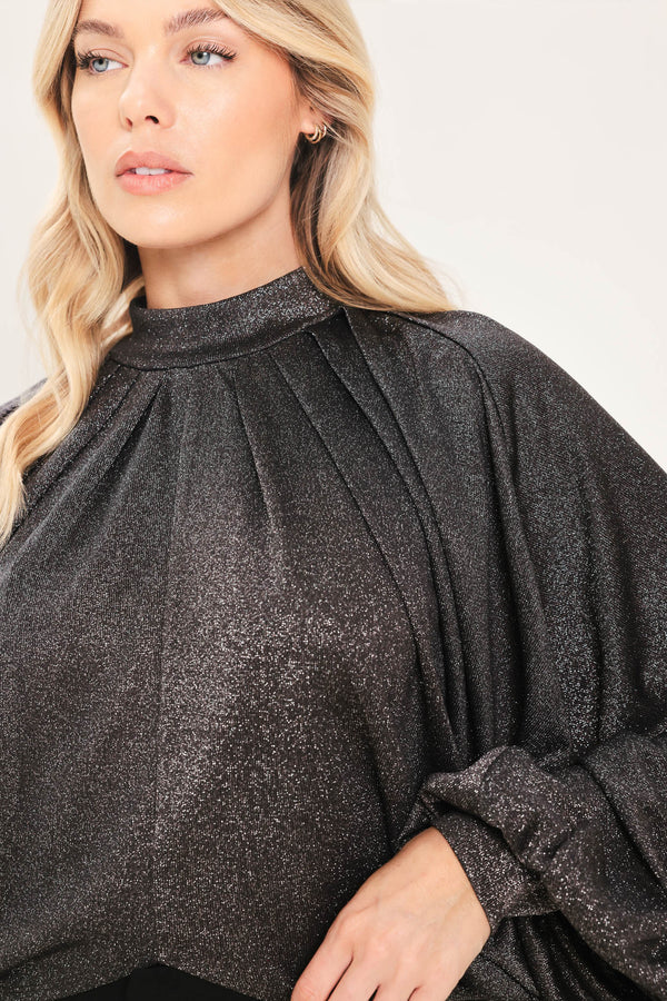 A woman modeling a dark gray metallic high-neck blouse with voluminous balloon sleeves | Flying Tomato