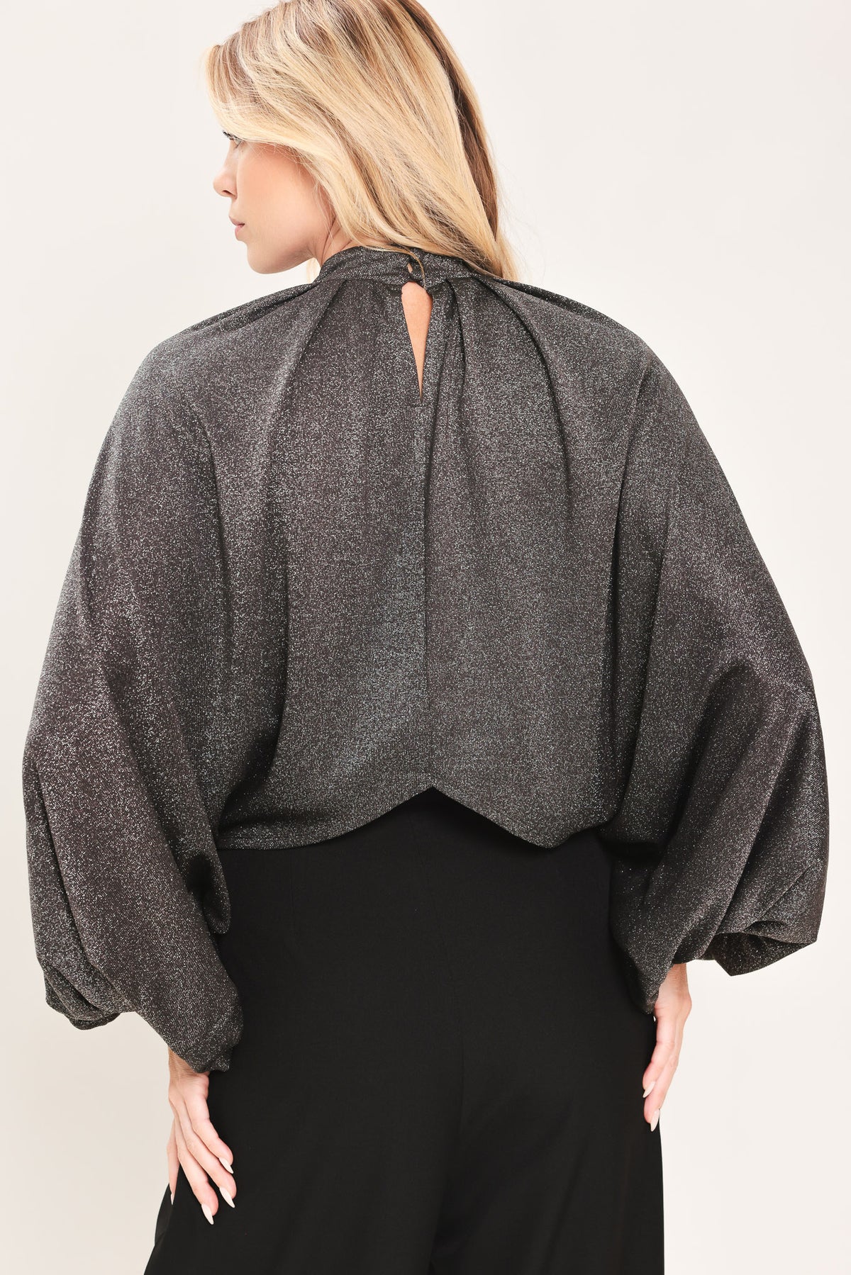 A woman modeling a dark gray metallic high-neck blouse with voluminous balloon sleeves | Flying Tomato