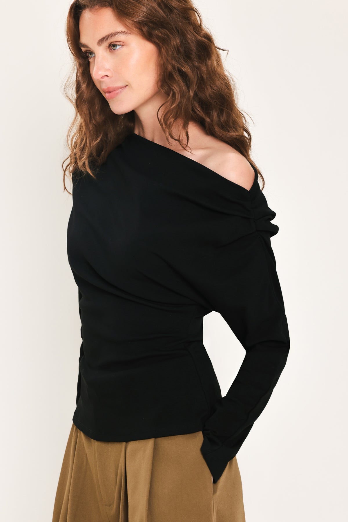 Woman wearing a long sleeve asymmetrical neck black top | Flying Tomato