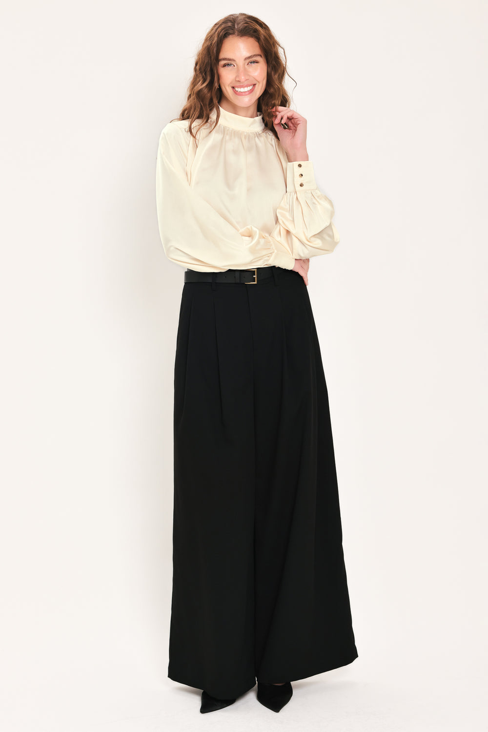 Woman wearing a long sleeve mock neck cream beige blouse | Flying Tomato