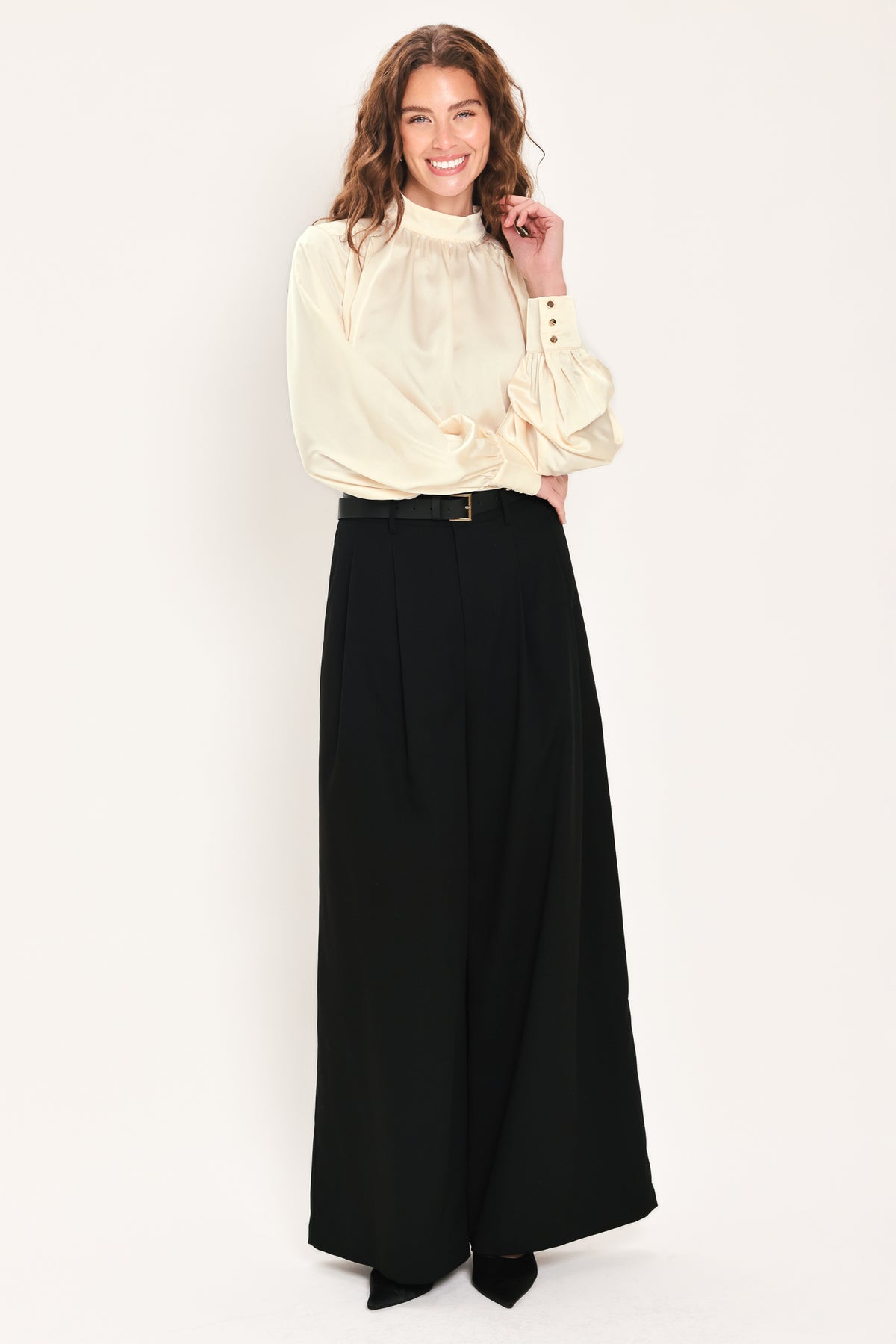 Woman wearing a long sleeve mock neck cream beige blouse | Flying Tomato