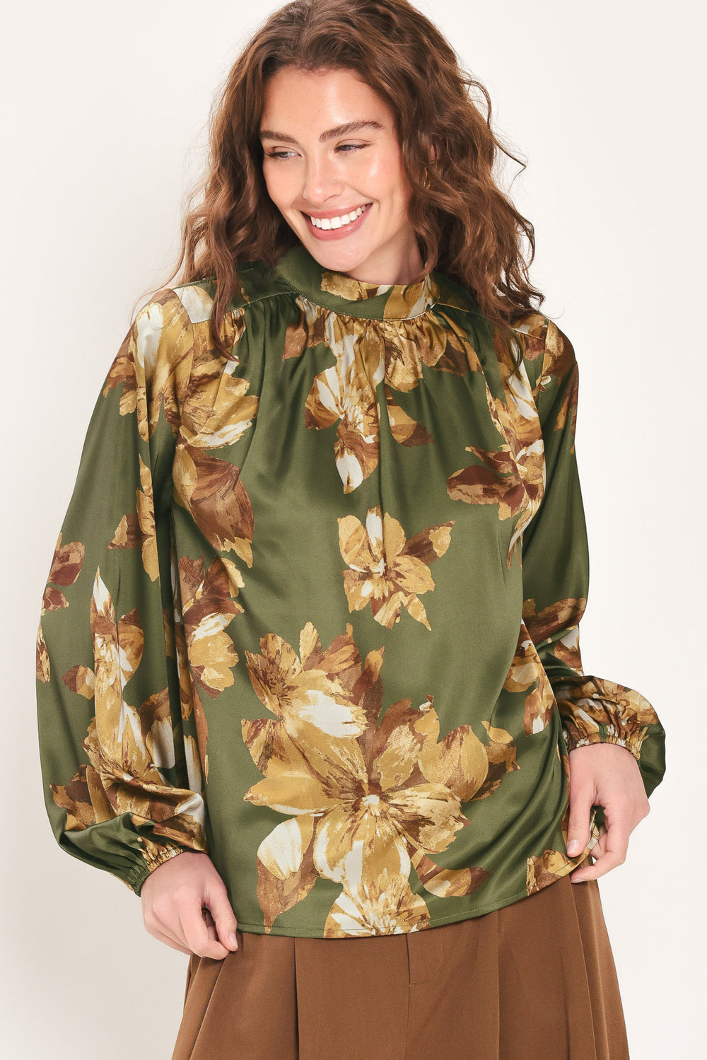 Woman wearing an olive green long sleeve top with a mock neckline and brown floral print | Flying Tomato