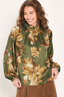Woman wearing an olive green long sleeve top with a mock neckline and brown floral print | Flying Tomato