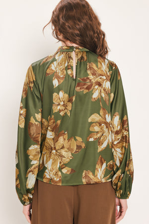 Woman wearing an olive green long sleeve top with a mock neckline and brown floral print | Flying Tomato