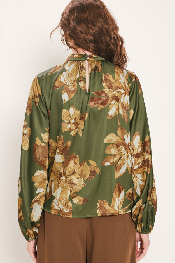 Woman wearing an olive green long sleeve top with a mock neckline and brown floral print | Flying Tomato