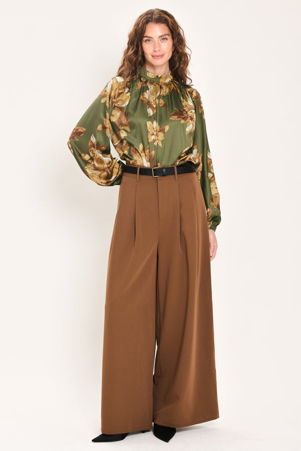 Woman wearing an olive green long sleeve top with a mock neckline and brown floral print | Flying Tomato